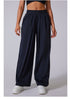 Front view of black wide-leg lounge pants with high waist, paired with white sneakers and matching crop tops.