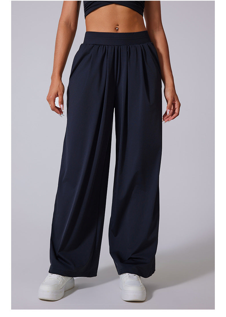 Front view of black wide-leg lounge pants with high waist, paired with white sneakers and matching crop tops.