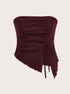 A close-up detail shot of burgundy ribbed fabric with lettuce edge trim and mesh panels showing garment construction