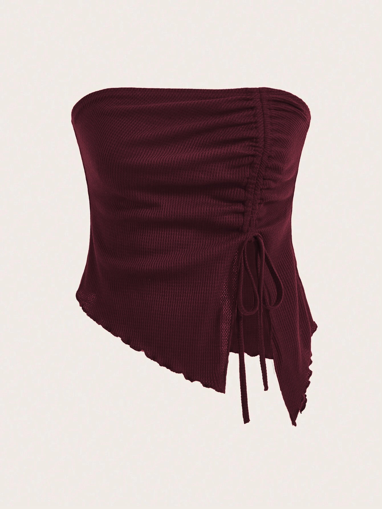 A close-up detail shot of burgundy ribbed fabric with lettuce edge trim and mesh panels showing garment construction