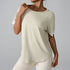 Beige workout top with white cuff detail showing relaxed fit and premium stretch material
