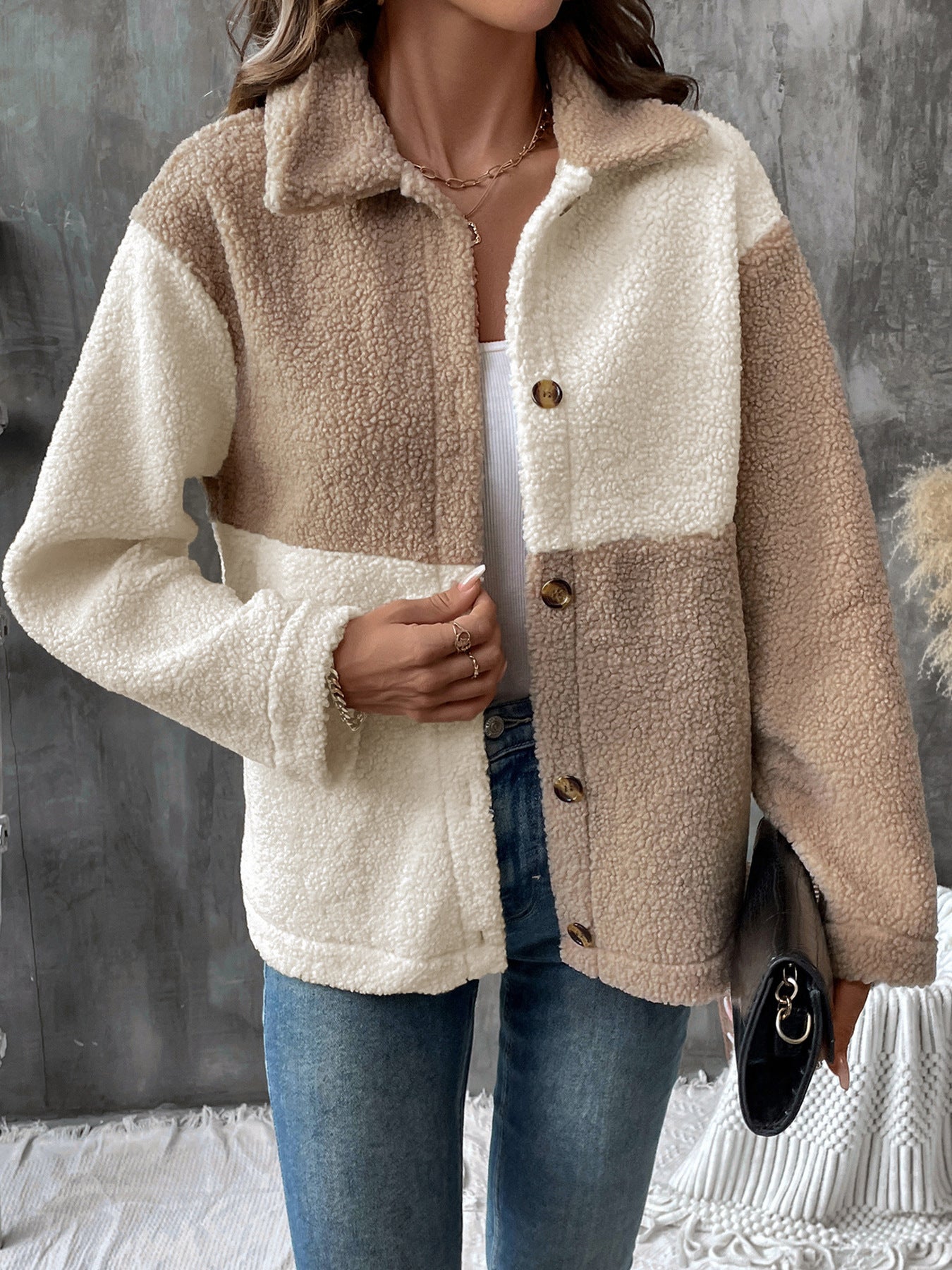 Two-tone beige and cream sherpa jacket with button front over white tank top and jeans