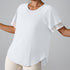 White athletic top with mesh sleeve cuffs displayed with cream-colored leggings, showing versatile style