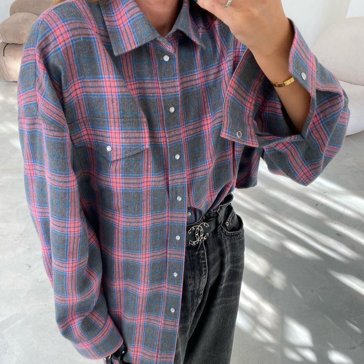 Purple and gray plaid flannel shirt with black jeans and gold bracelet