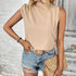 Beige mock neck sleeveless top paired with distressed denim shorts