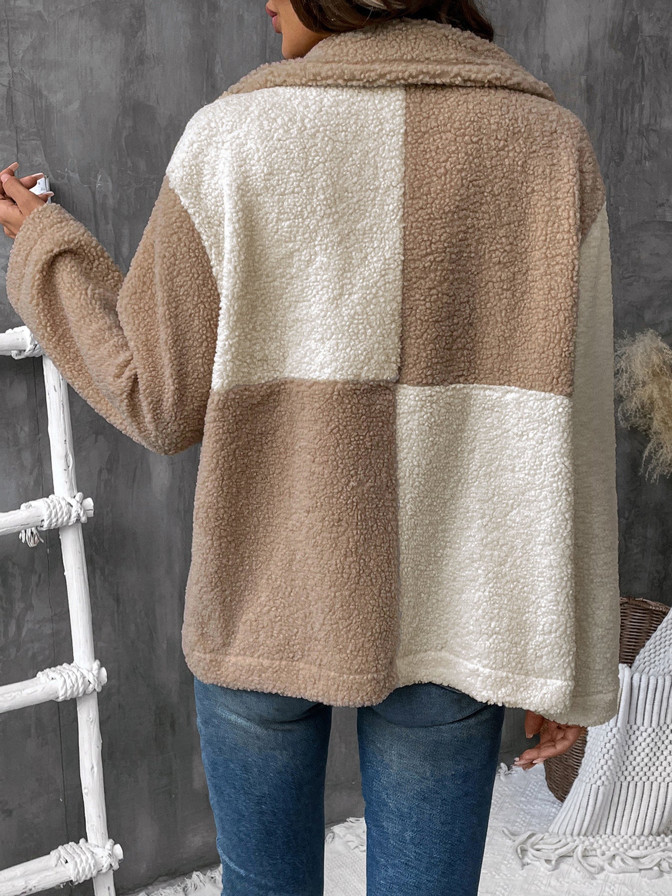 Two-tone beige and cream sherpa jacket with button front over white tank top and jeans