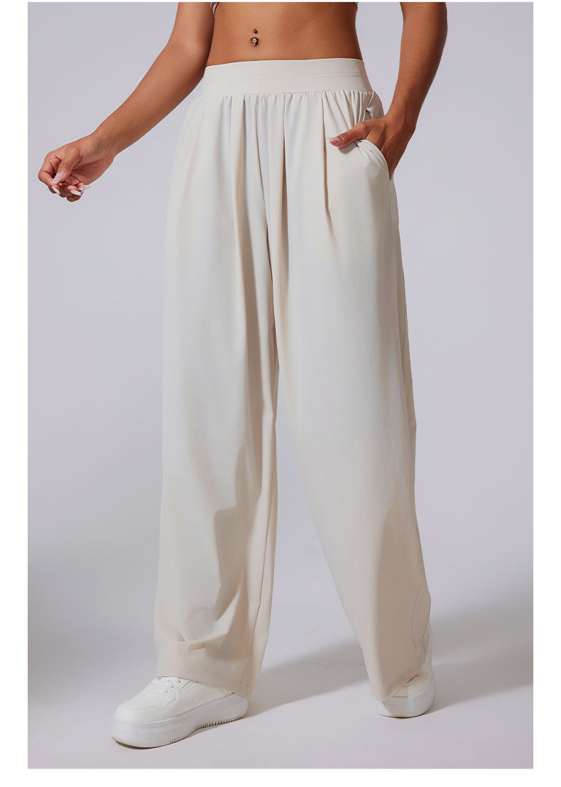 Side view of ivory wide-leg lounge pants with high waist, paired with white sneakers.