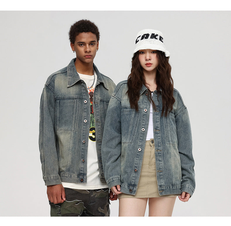 A man and woman are standing against a gray backdrop. Both wearing vintage-wash denim jackets with button fronts and chest pockets over casual tops