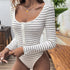  A woman wearing the striped bodysuit with jeans, highlighting the ribbed texture and button details.