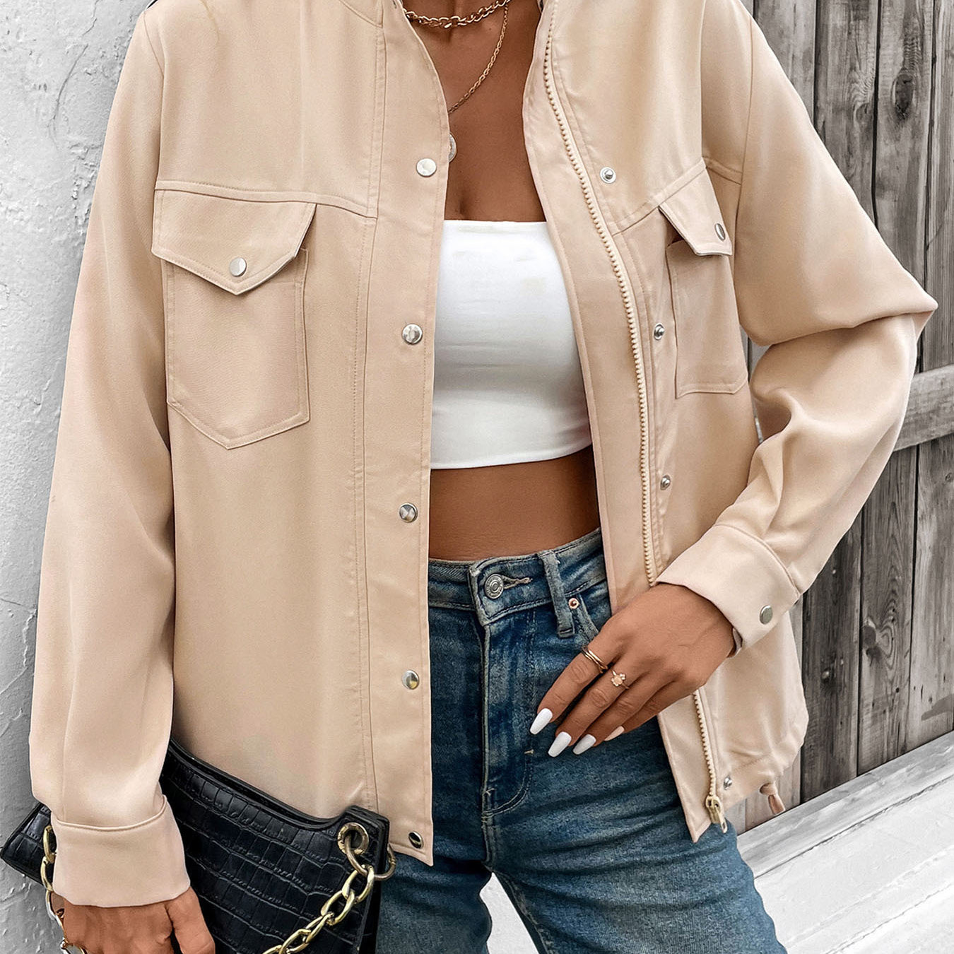 Women's beige utility jacket with front pockets and button details, styled casually with crop top