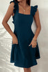 Navy blue A-line dress with ruffle straps and square neckline, shown with gold chain accessories