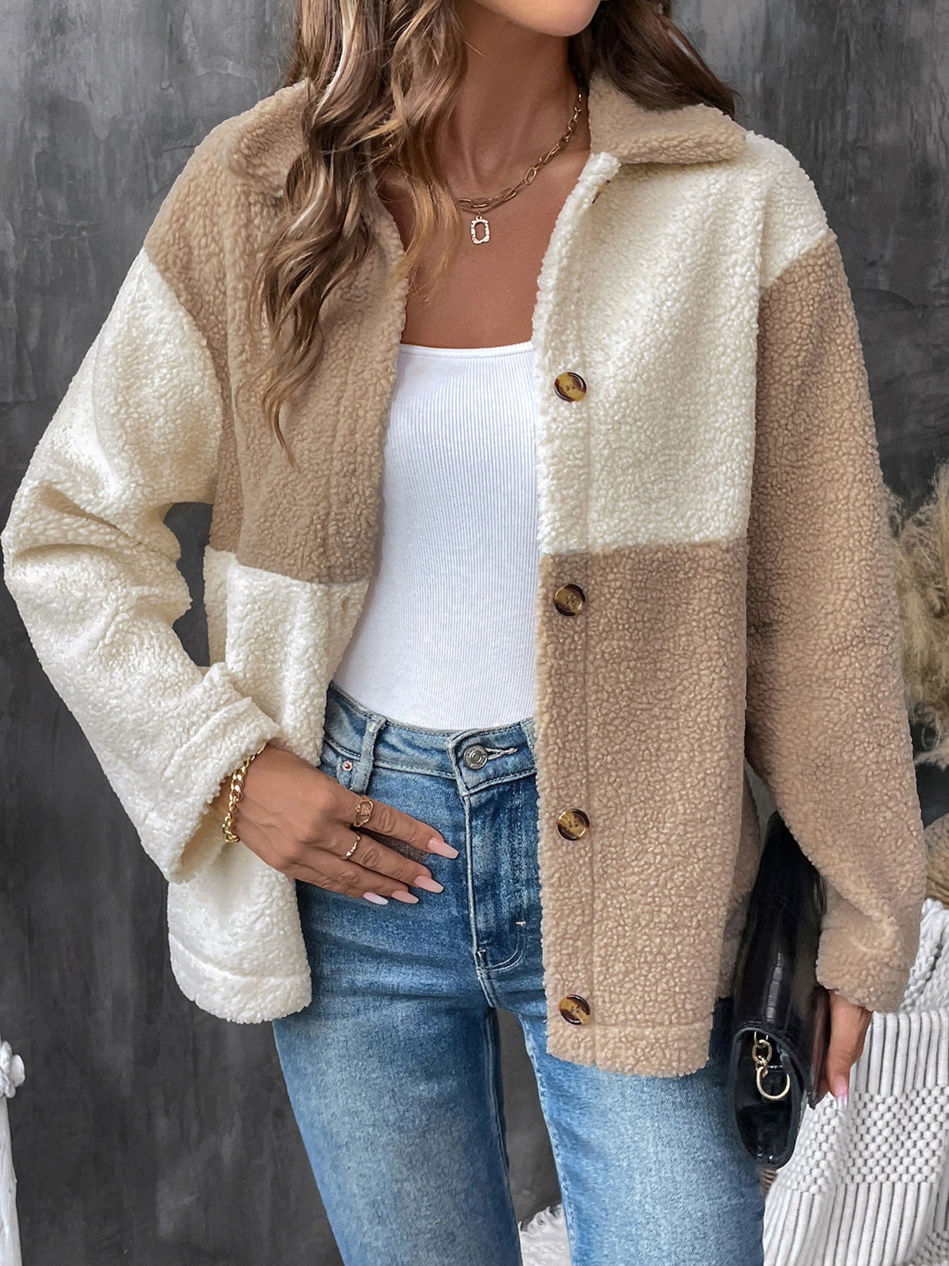 Two-tone beige and cream sherpa jacket with button front over white tank top and jeans
