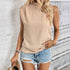 Beige mock neck sleeveless top paired with distressed denim shorts