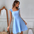 Light blue knee-length dress with ruffle straps and fitted waist, shown against white wall with antique mirror
