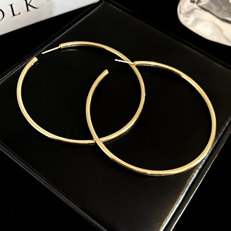 Gold simple hoop earrings on black presentation box