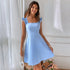 Front view of light blue A-line dress with ruffle straps and fitted bodice, accessorized with delicate jewelry