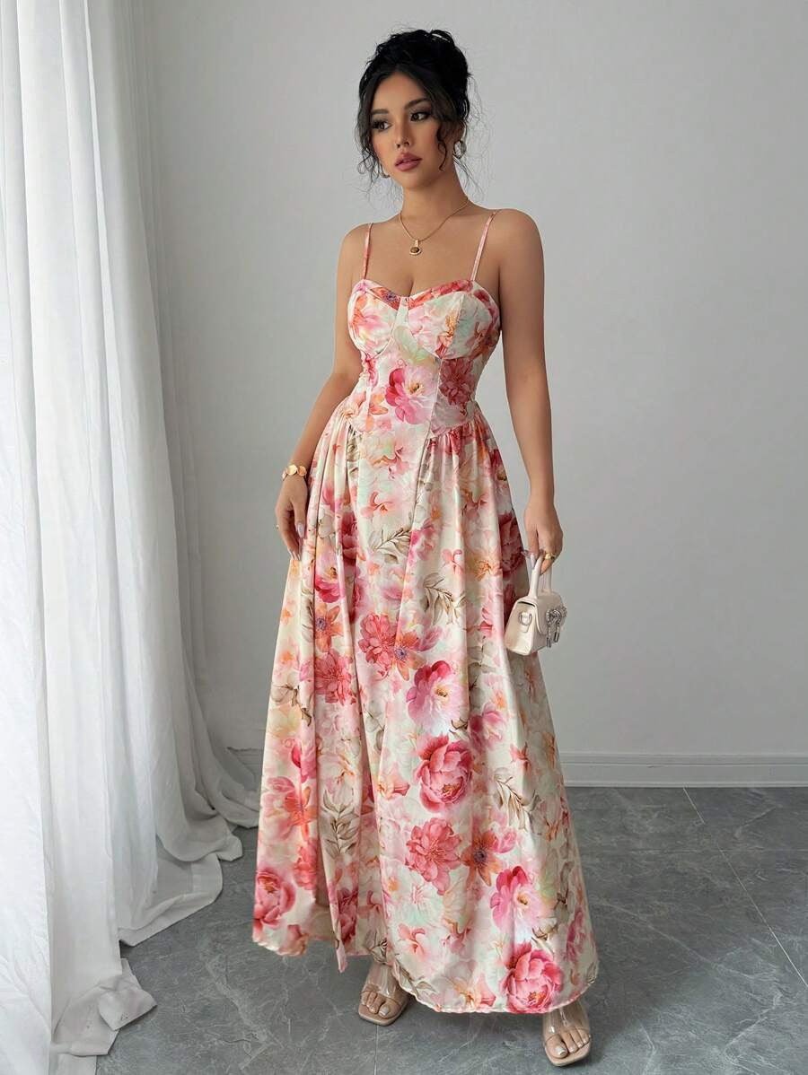Woman wearing a floral dress standing against a plain background
