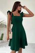 Forest green A-line dress with ruffle straps and square neckline, paired with woven handbag and sunglasses