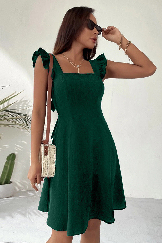 Forest green A-line dress with ruffle straps and square neckline, paired with woven handbag and sunglasses