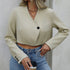 Women's cropped blazer in beige styled with high-waist jeans and layered necklaces