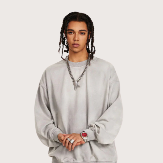 Male model in gray oversized sweatshirt and sweatpants set with white sneakers, styled in relaxed streetwear look.