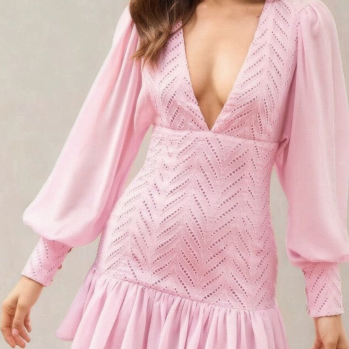 Woman wearing a pink dress with long sleeves.