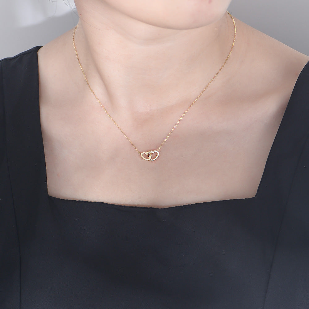 Woman wearing gold S925 double heart necklace with delicate chain and heart pendant.