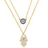 Close-up of gold layered necklace featuring blue evil eye charm and Hamsa pendant