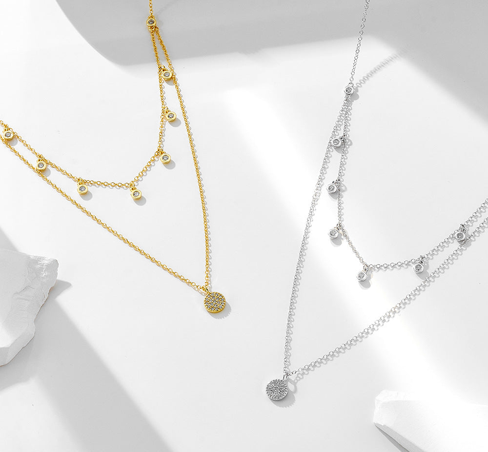 Gold and silver layered CZ choker necklaces side by side on white surface.