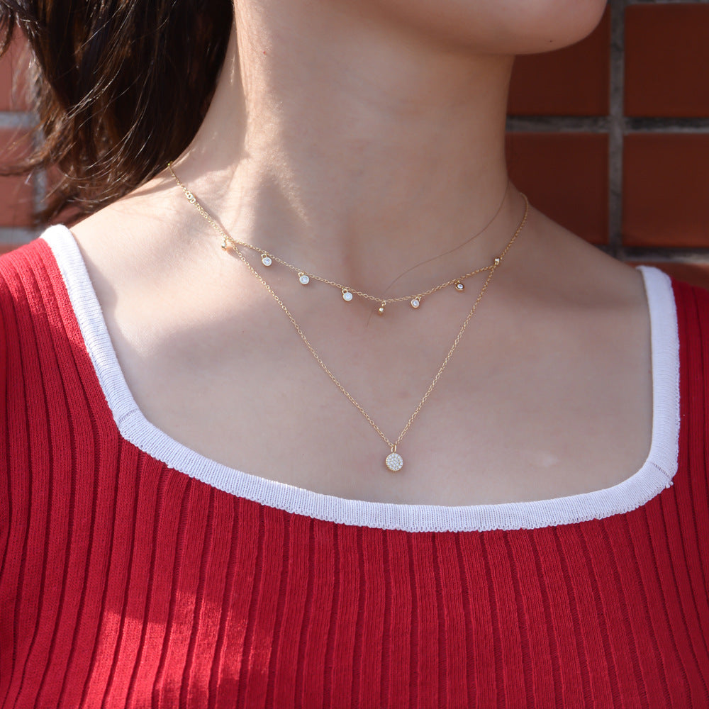 Woman wearing gold double-layer CZ choker necklace with disc pendant.