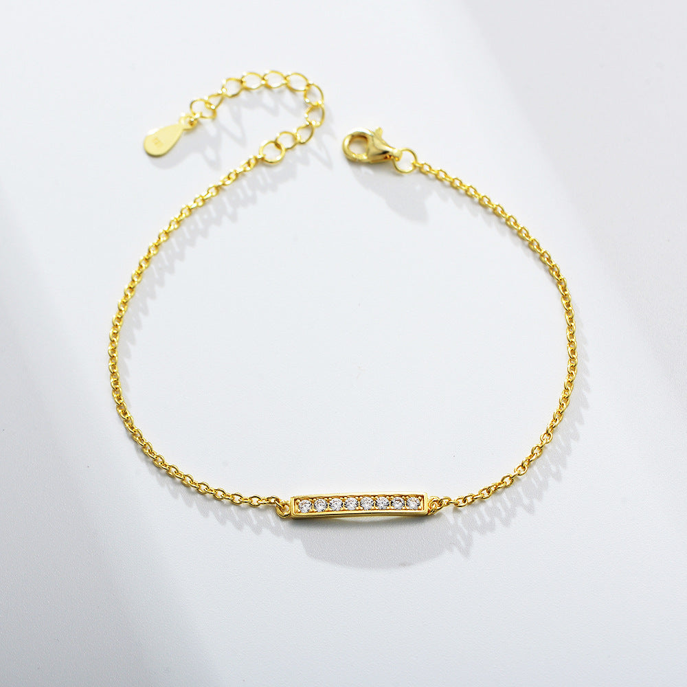 Gold bracelet with a horizontal CZ bar centerpiece on a delicate chain.