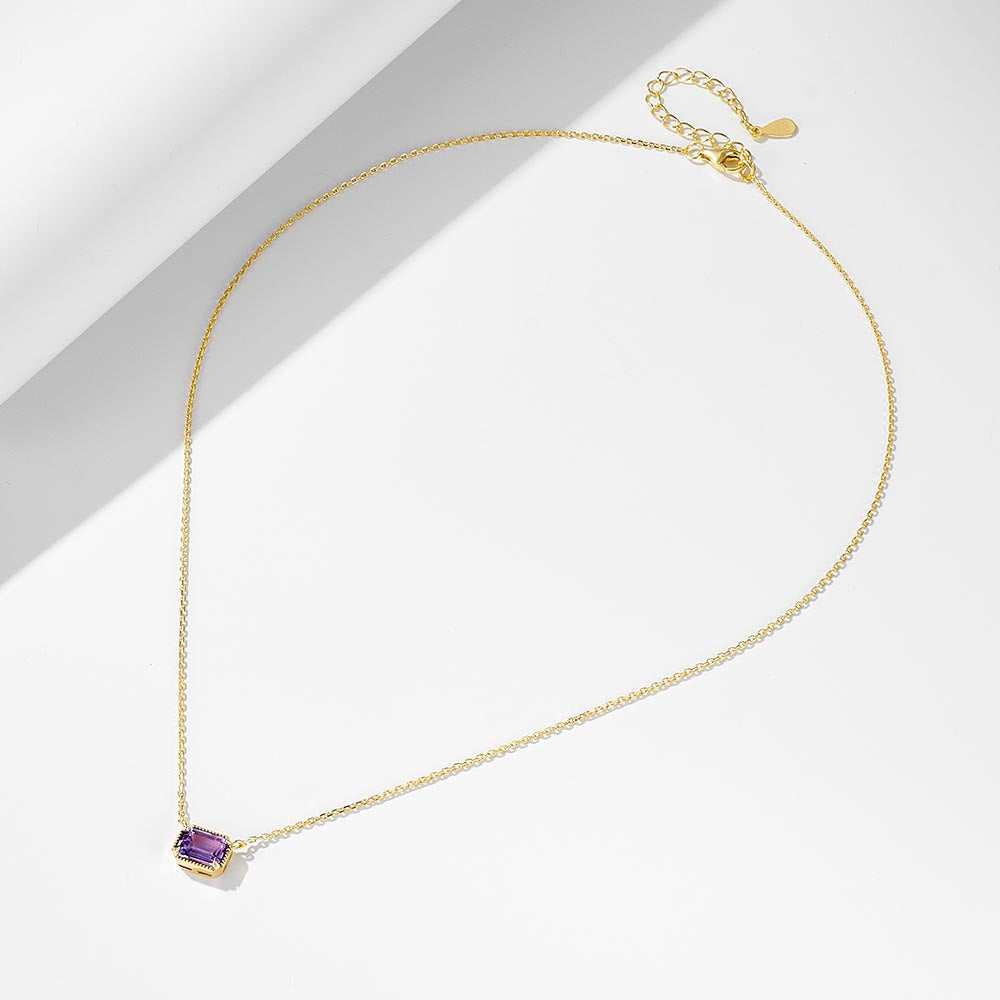 Gold-plated sterling silver amethyst pendant necklace with adjustable chain laid flat.