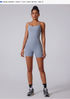 Model Amanda wearing sky blue one-piece bodysuit with sneakers, height 173cm, standing against light gray background