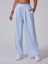  Model wearing powder blue wide-leg pants with high waistband, side pockets and pleated front, paired with white sneakers