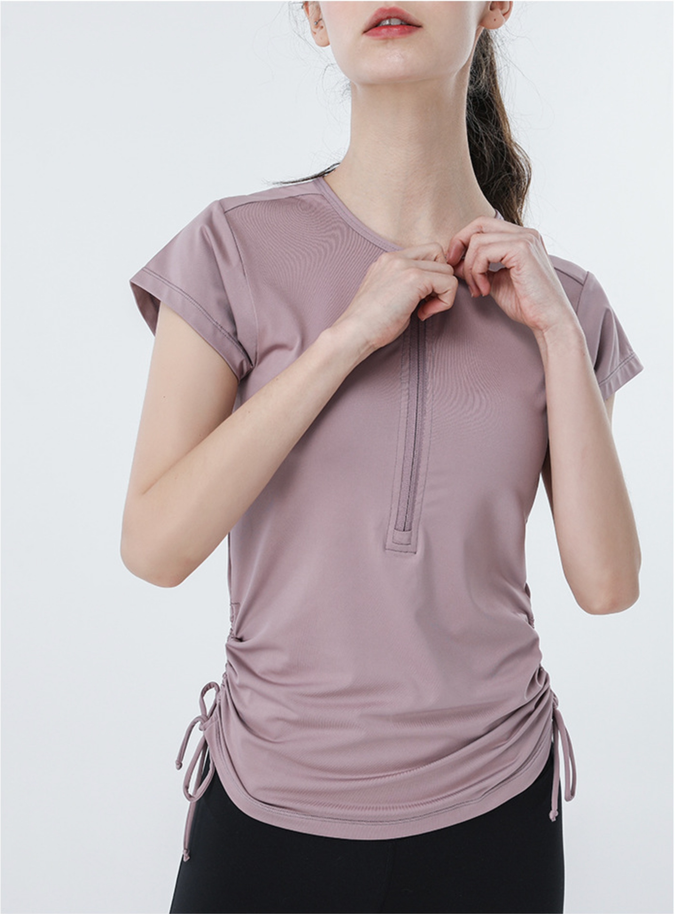 Close-up of mauve athletic tee with front zipper and cap sleeves, minimalist workout style