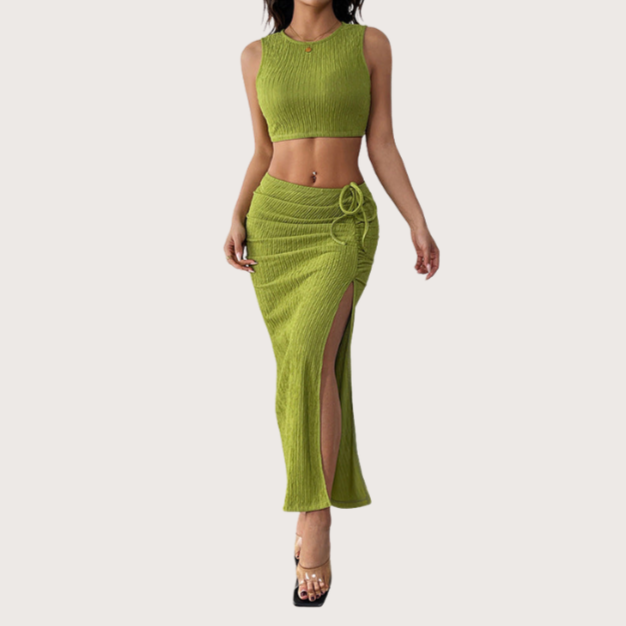 Woman wearing a green ribbed knit crop top with matching high-slit skirt, styled in a chic two-piece summer outfit.