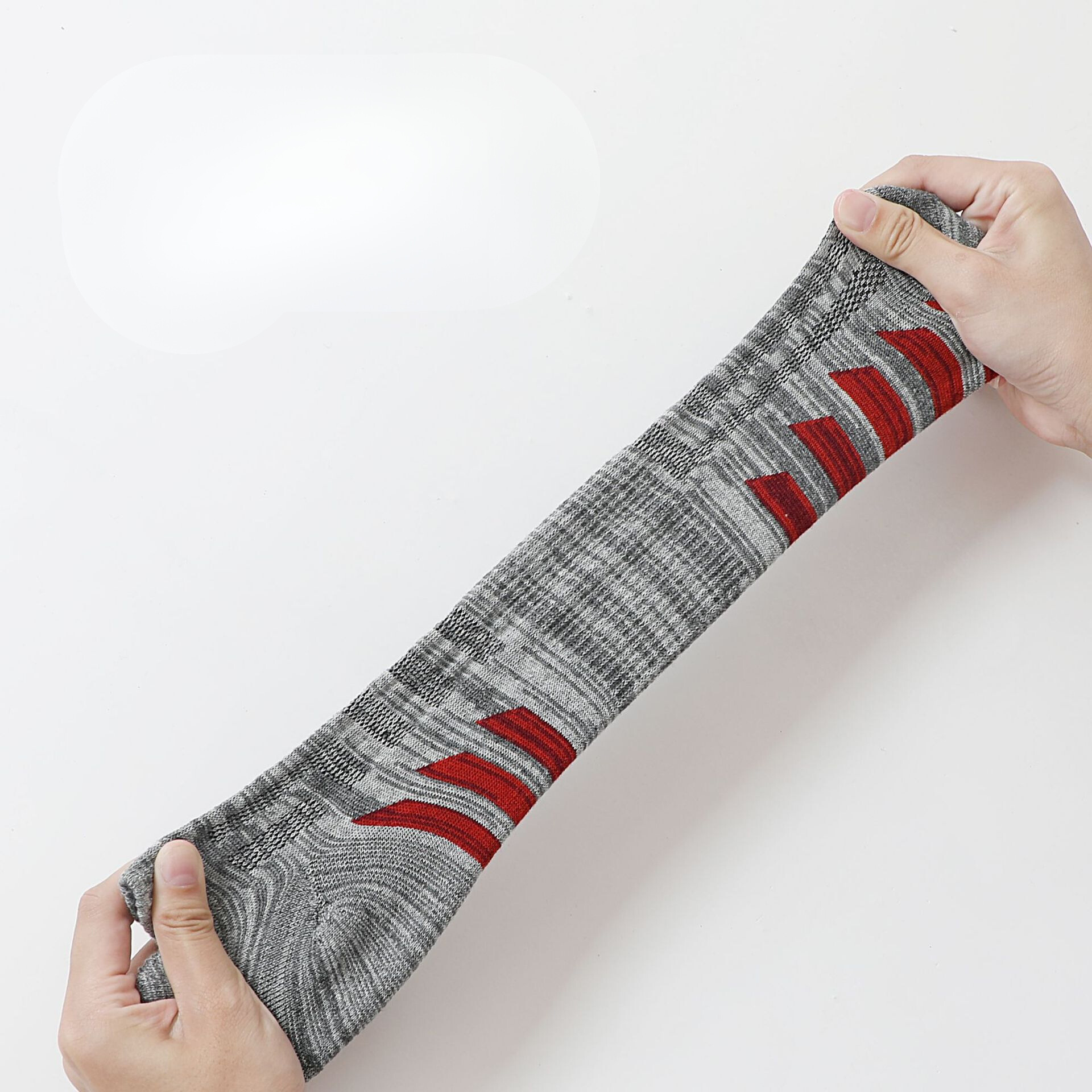 Stretch test showing gray melange athletic sock with red striped cushioning pattern and moisture-wicking knit texture