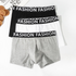 Set of three men's boxer briefs in black, white and gray with matching "FASHION" logo waistbands displayed flat