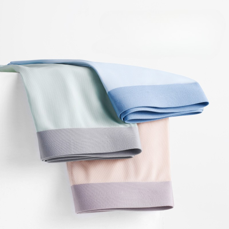 Collection of men's boxer briefs in pastel colors including light blue, mint green, and blush pink with contrasting waistbands