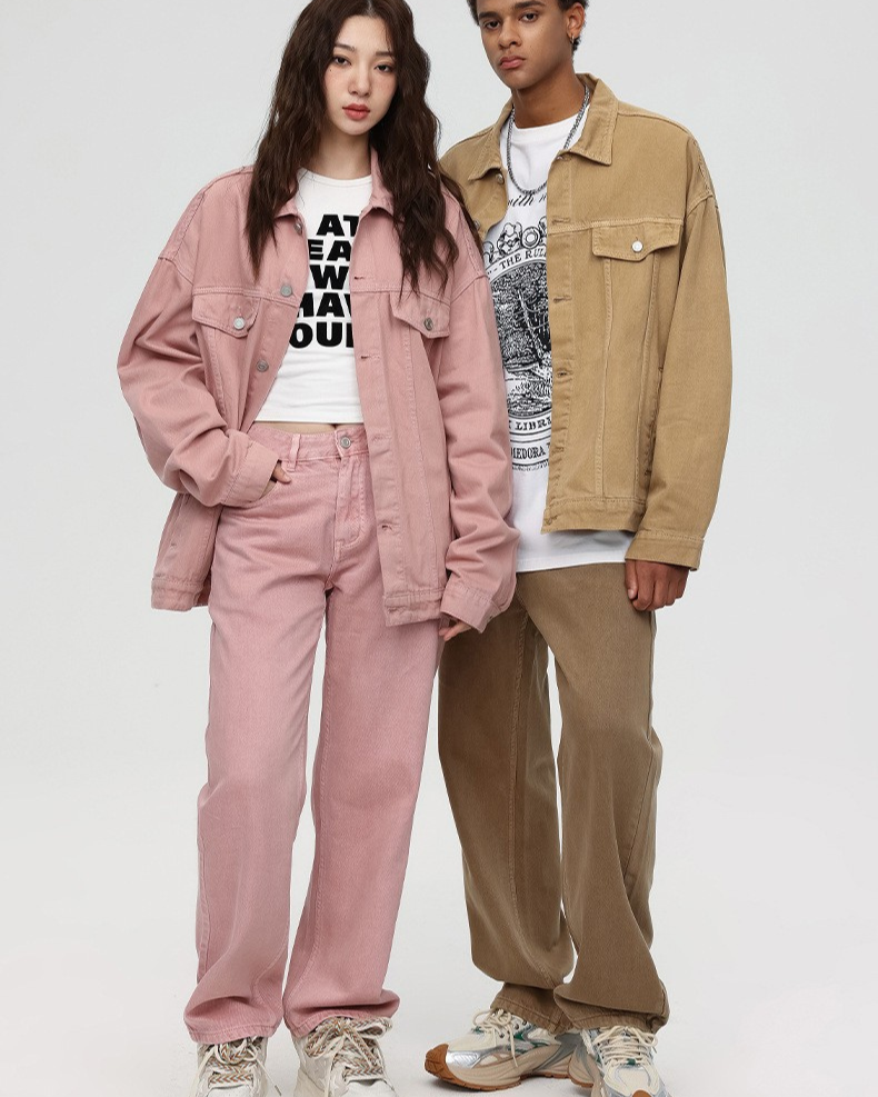 A woman and man standing together modeling coordinated outfits with pink and tan denim jackets, wide-leg pants, and graphic tees