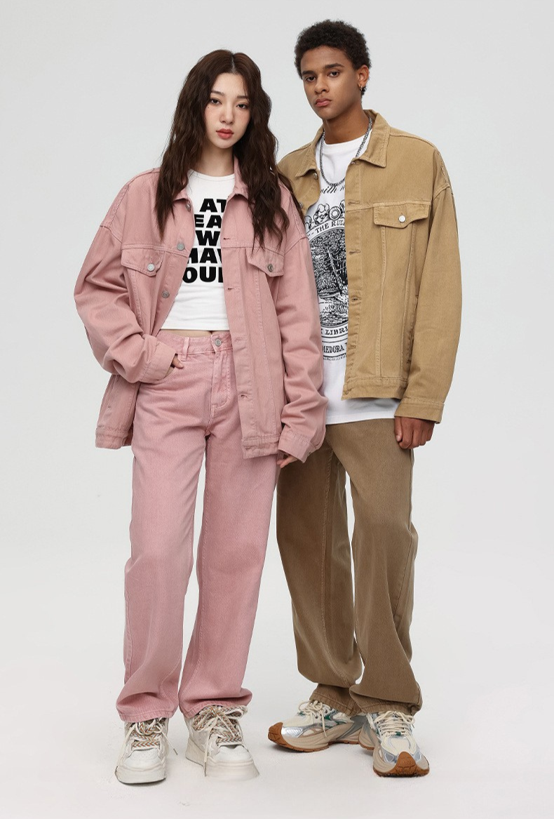 A woman and man standing together modeling coordinated outfits with pink and tan denim jackets, wide-leg pants, and graphic tees