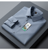 A folded charcoal dress shirt displayed on dark gray surface. Rich dark fabric with clean collar lines and brand tag visible