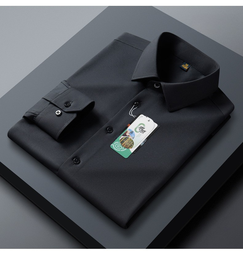 A folded black dress shirt displayed on dark gray surface. Sleek collar detail and buttoned placket visible with brand tag