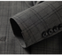 Close-up of gray suit jacket sleeve showing button detail and plaid fabric texture