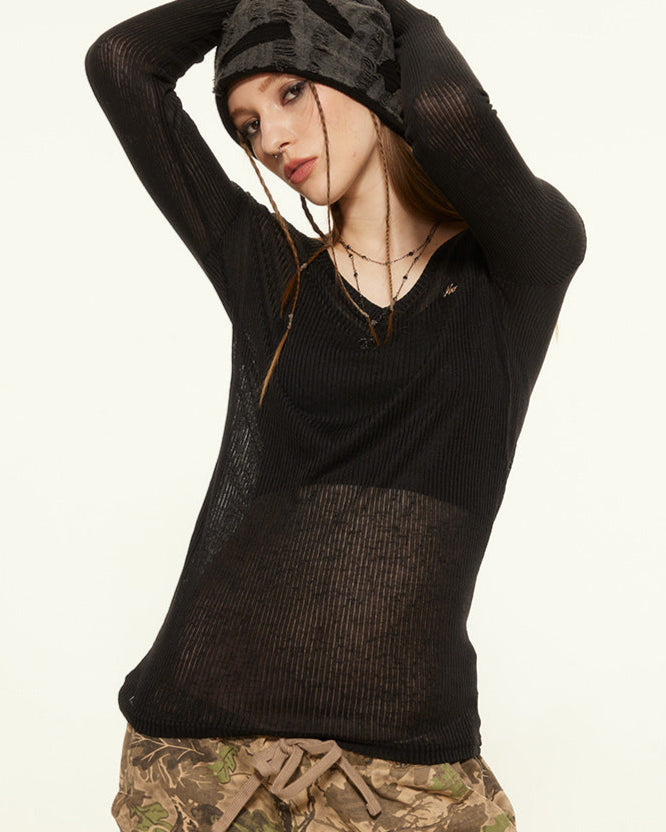 Black sheer off-shoulder top styled with distressed beanie and cargo pants in edgy Y2K fashion.