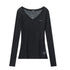 Black sheer ribbed V-neck long sleeve top with raw-edge off-shoulder design in flat lay background. 