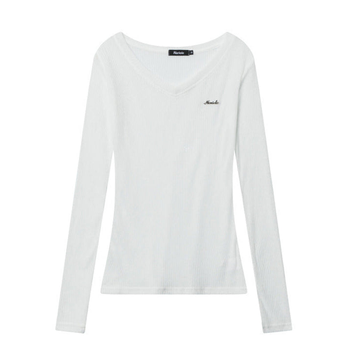White sheer ribbed V-neck long sleeve top with raw-edge off-shoulder design in flat lay background.