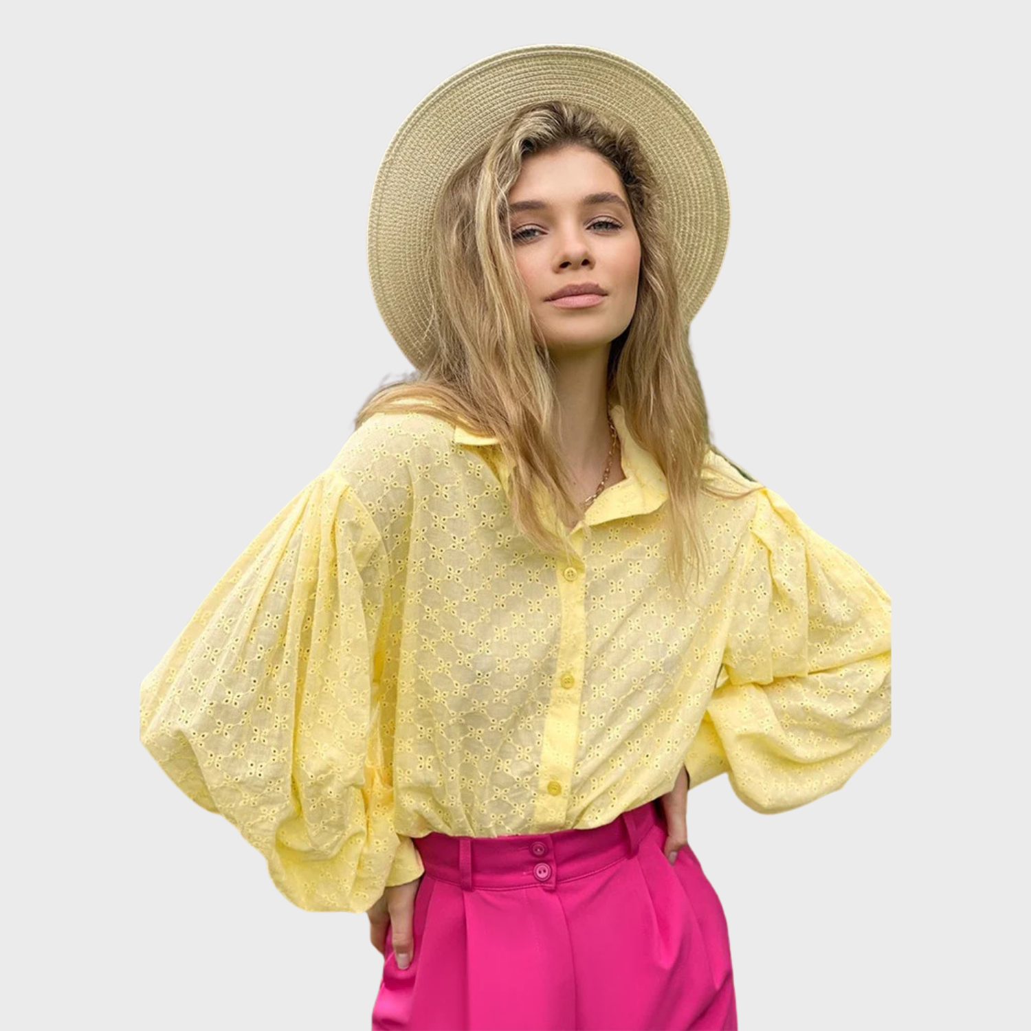 Yellow eyelet blouse with puff sleeves and button front, styled with a straw hat.