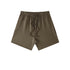 Dark olive cotton shorts with elastic waistband and drawstring, displayed flat on white background