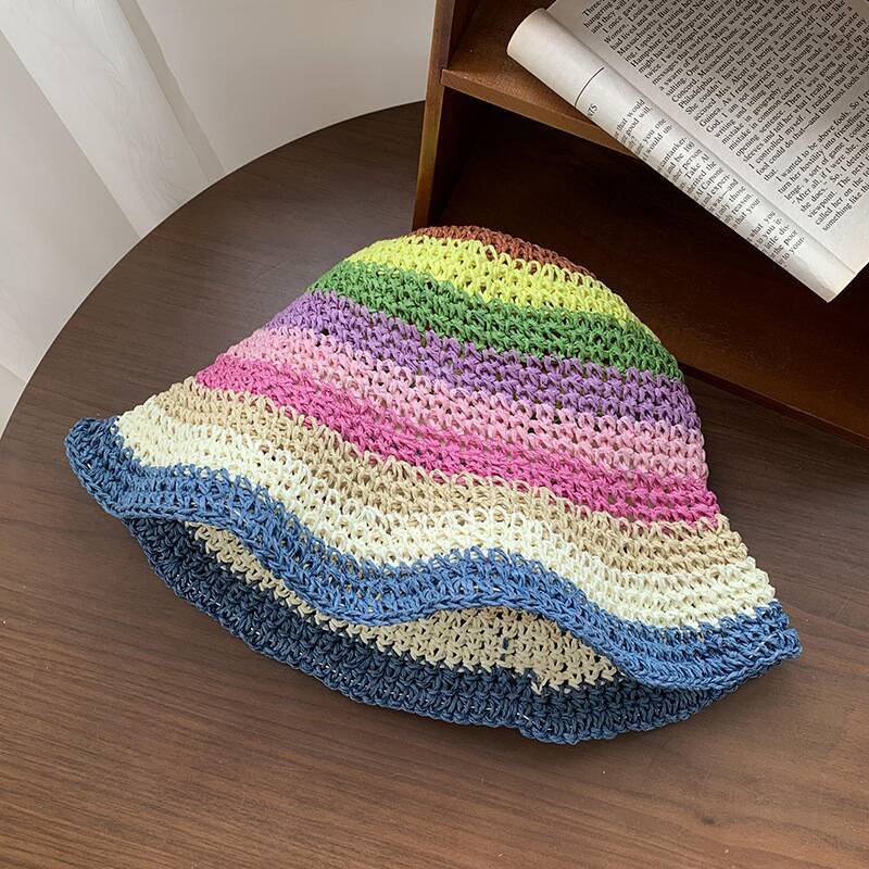 A vibrant crochet straw hat with multicolor stripes and a deep blue brim, adding a playful and bold summer style.
